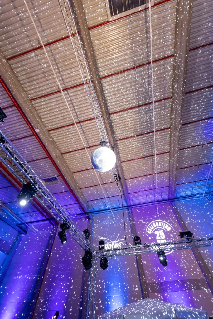 Sound Patrol Avides Media 25 Jahre: Lagerhalle als Eventlocation für das Firmenjubiläum mit violettem Uplighting und Bühne